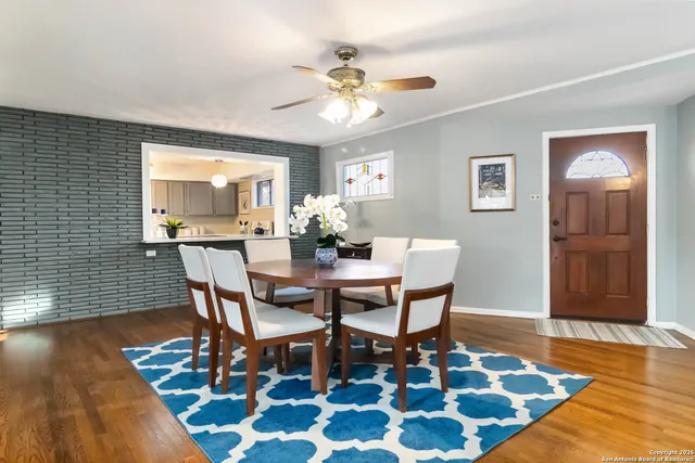 a dining room with wooden floor and a chandelier