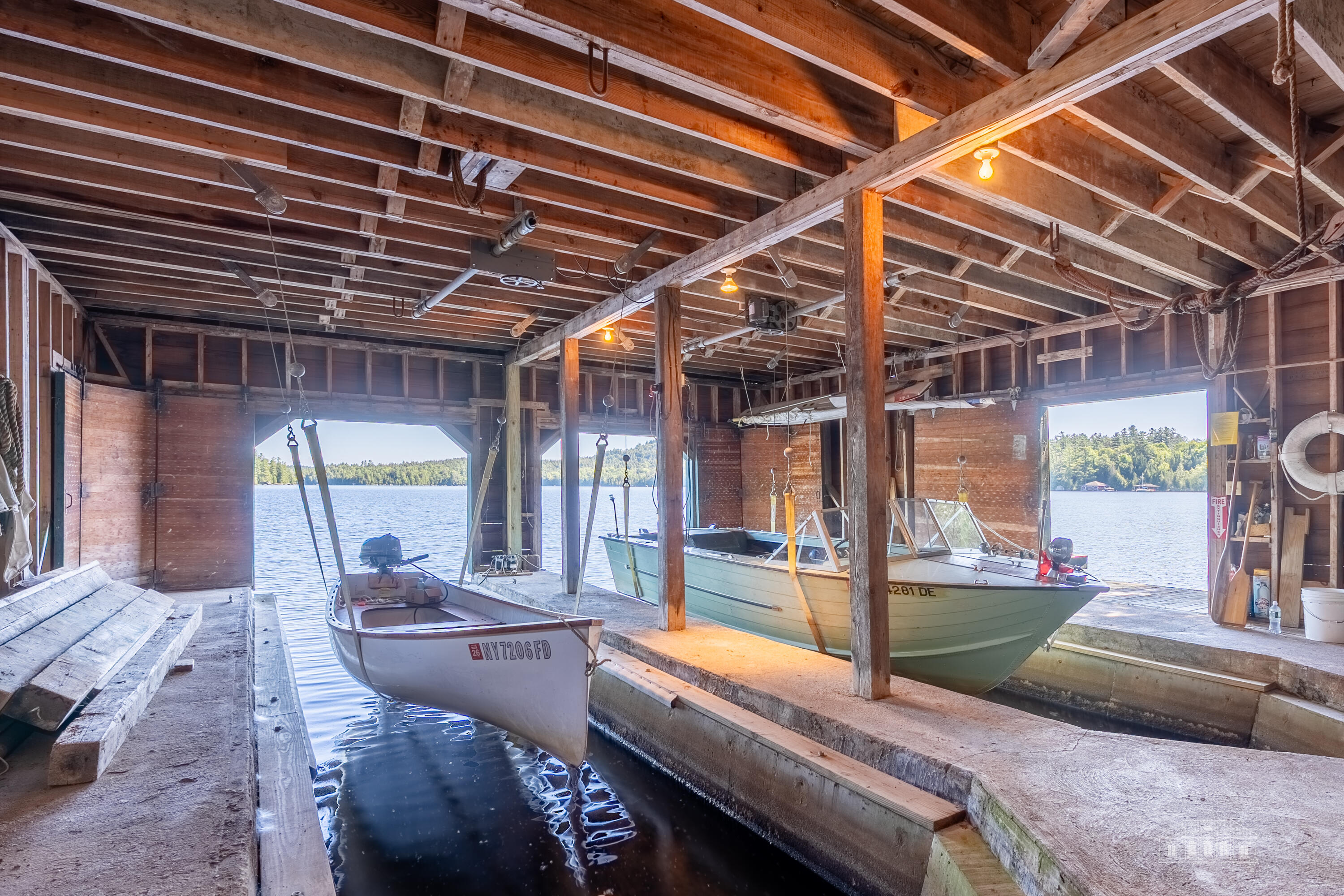 144 County Road Tupper Lake, NY 12986 - Photo 71 of 76 Big Boathouse -has two electric boat hoists. The second floor opens to the flat roof below and gives a view of the bay.