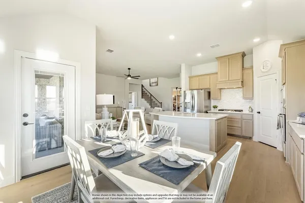 a dining room with stainless steel appliances kitchen island granite countertop a table and chairs