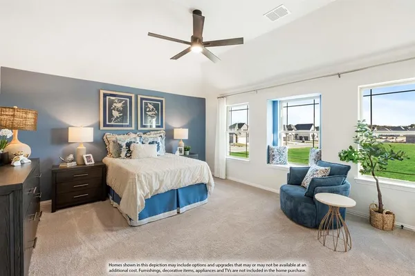 a spacious bedroom with a bed a couch and a potted plant on the dresser