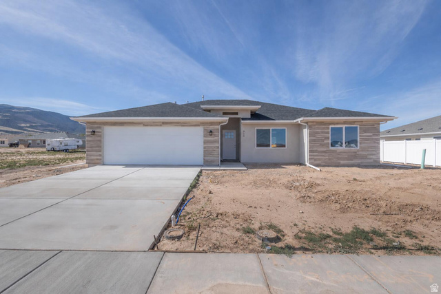 910 East Remington Road Cedar City, UT 84721 - Photo 1 of 29 Contemporary single-story residence featuring a two-car garage, stone veneer accents, and a stucco exterior