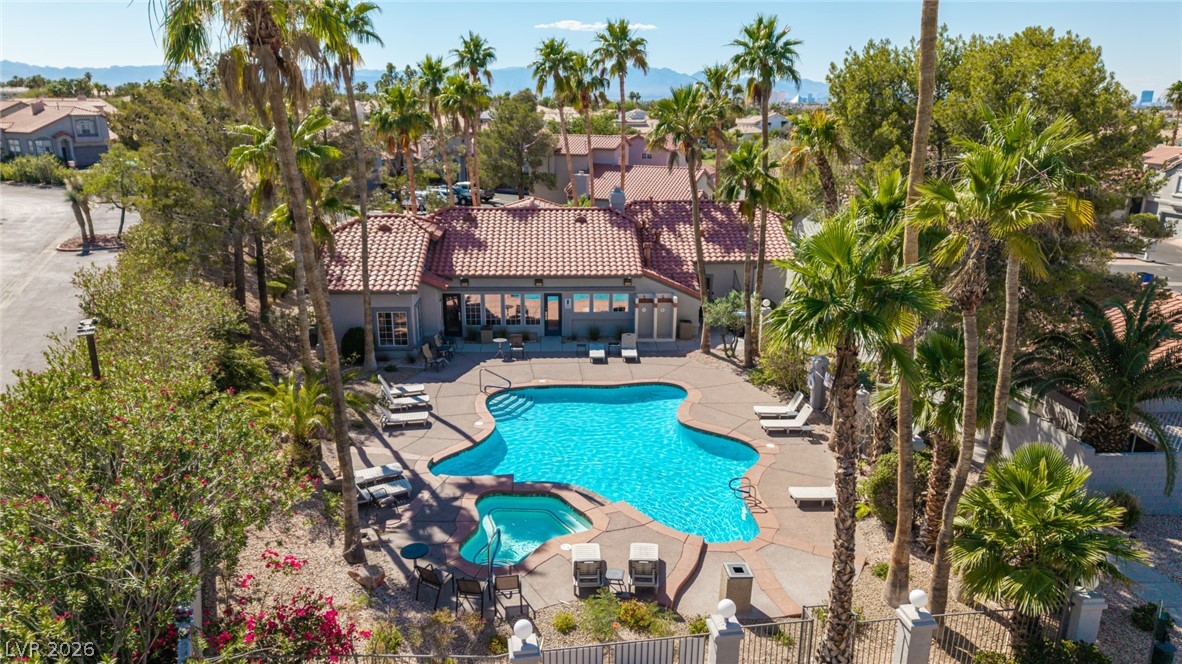 2223 Ramsgate Drive Henderson, NV 89074 - Photo 28 of 32 An inviting swimming pool and spa surrounded by lush palm trees, perfect for leisure.