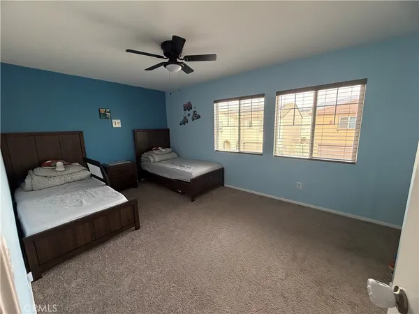 a spacious bedroom with two beds and window