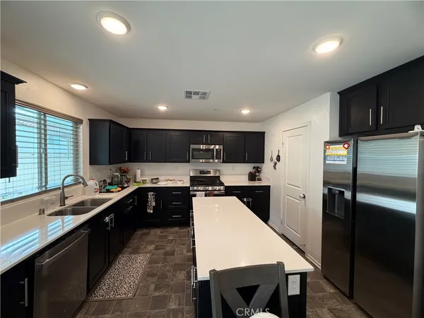 a kitchen with stainless steel appliances a sink stove and refrigerator