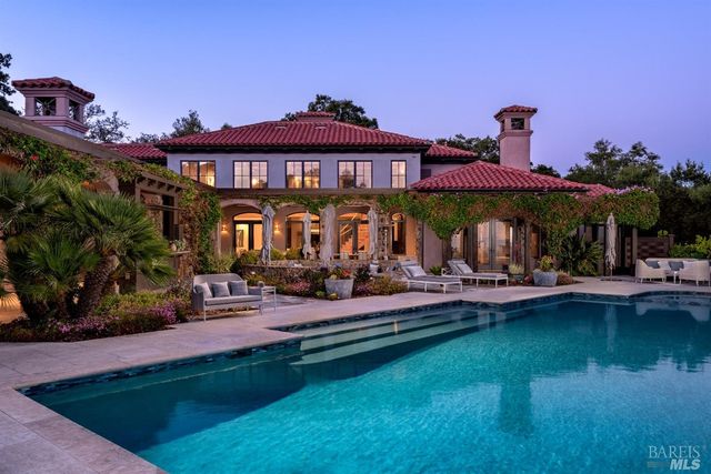 a view of a house with swimming pool and sitting area
