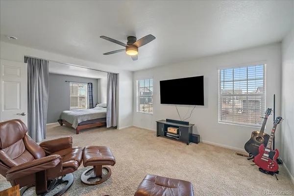 a living room with furniture a flat screen tv and a window