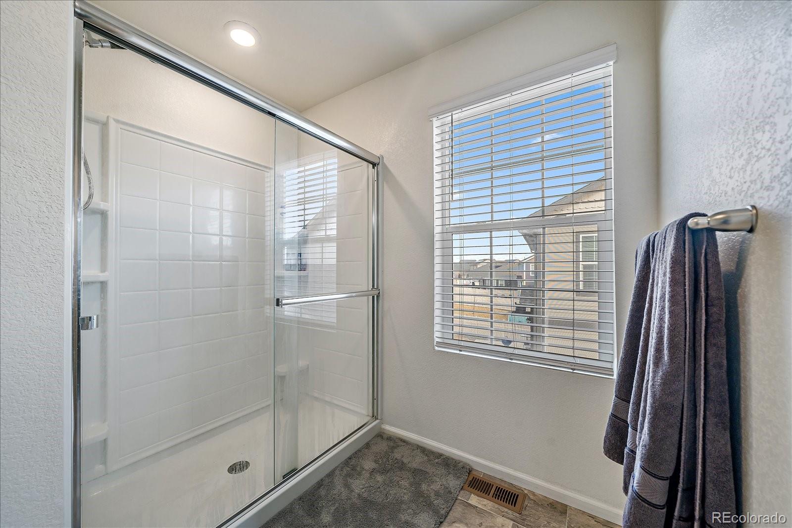 10097 Cedar Street Firestone, CO 80504 - Photo 22 of 37 a bathroom with a shower and a window