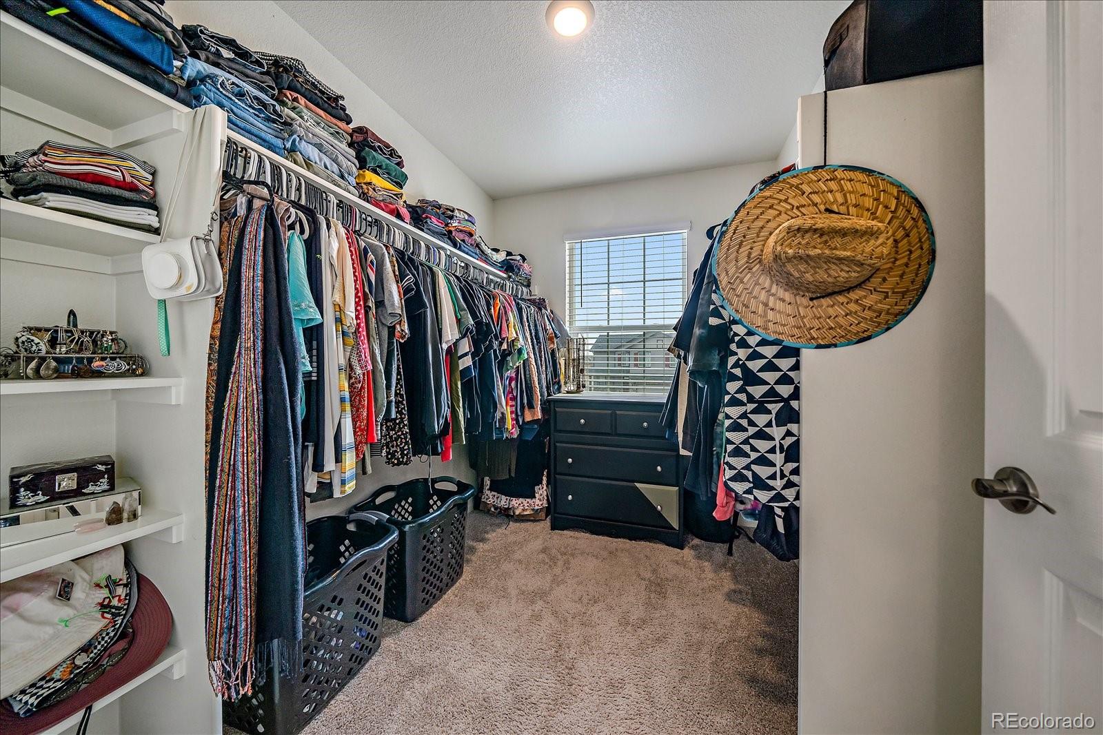 10097 Cedar Street Firestone, CO 80504 - Photo 23 of 37 a view of walk in closet with clothes and shoes