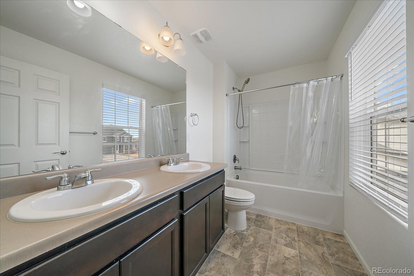 10097 Cedar Street Firestone, CO 80504 - Photo 25 of 37 a bathroom with a sink a toilet a mirror a bathtub and shower