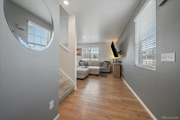 a living room with furniture a large window and a wooden floor