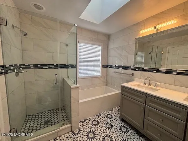 a bathroom with a sink a toilet a mirror and bathtub