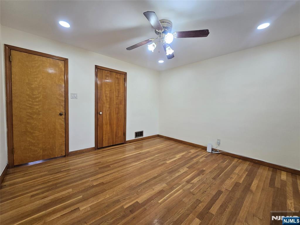 701 4th Street Secaucus, NJ 07094 - Photo 9 of 21 an empty room with wooden floor chandelier fan and windows