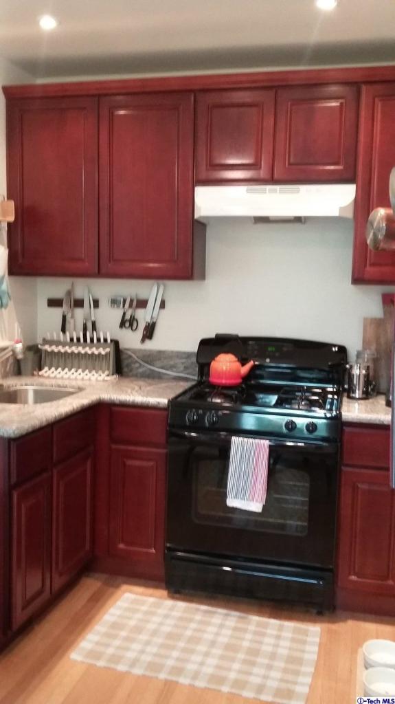 970 Cornell Road Pasadena, CA 91106 - Photo 9 of 14 a kitchen with wooden cabinets and a stove top oven