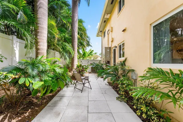 a front view of a house with a yard and potted plants