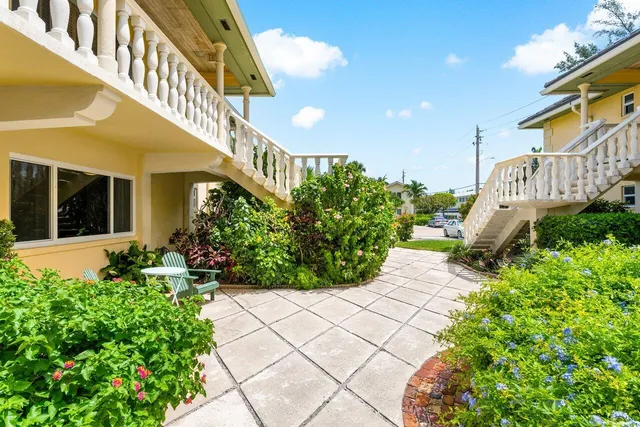 a front view of a house with a yard and potted plants