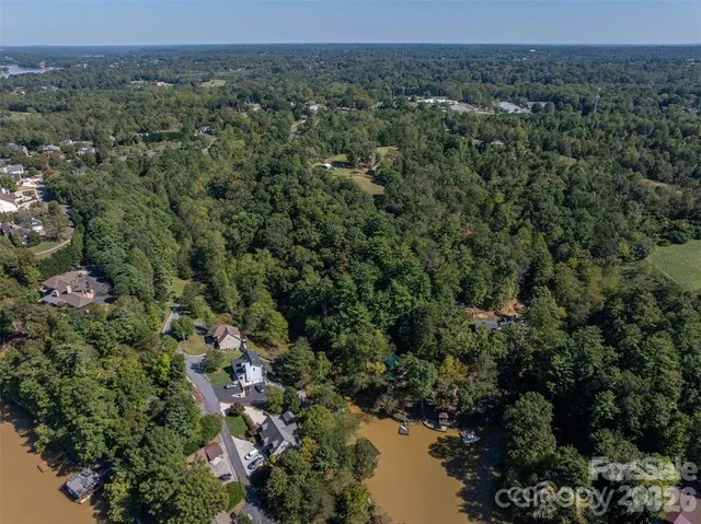 an aerial view of a houses with a yard and lake view