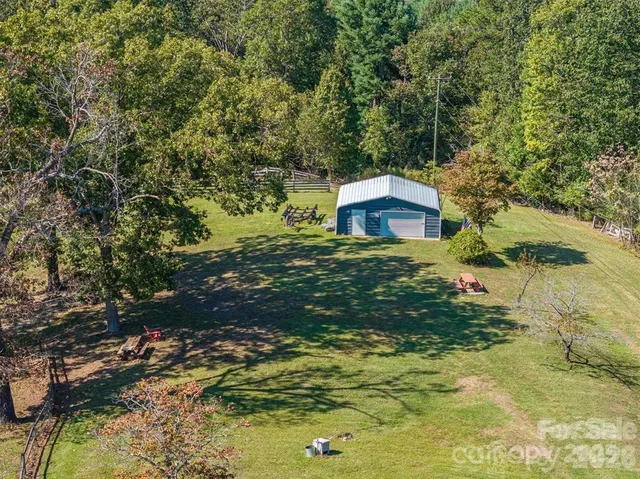 a backyard of a house with a yard and large tree