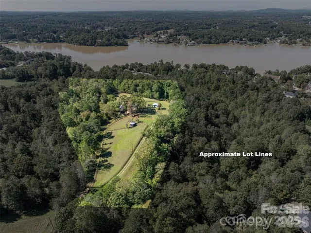 an aerial view of residential houses with outdoor space and lake view