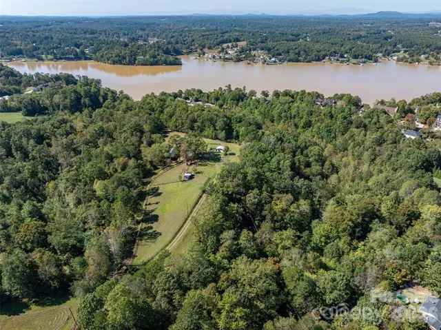an aerial view of residential houses with outdoor space and lake view