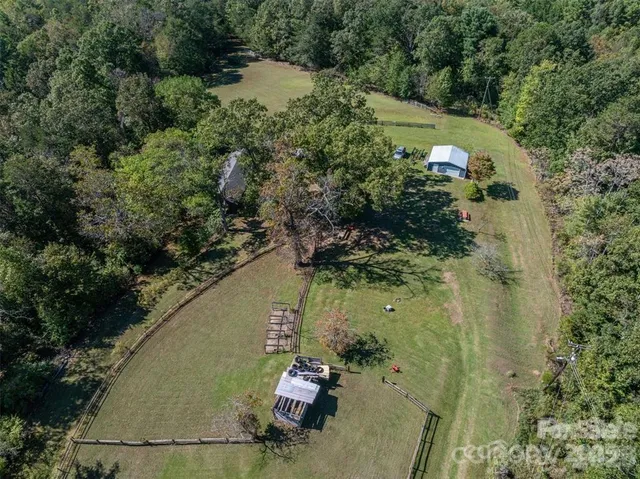 an aerial view of a house with a yard and lake view