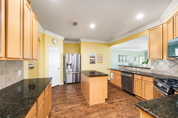 a kitchen with stainless steel appliances granite countertop a sink and a refrigerator