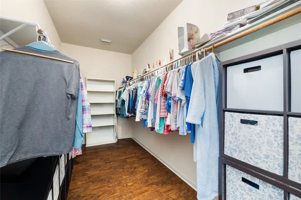 a view of walk in closet with clothes and shoes