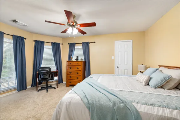 a bedroom with furniture and a ceiling fan