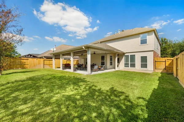 a view of a backyard with table and chairs under an umbrella