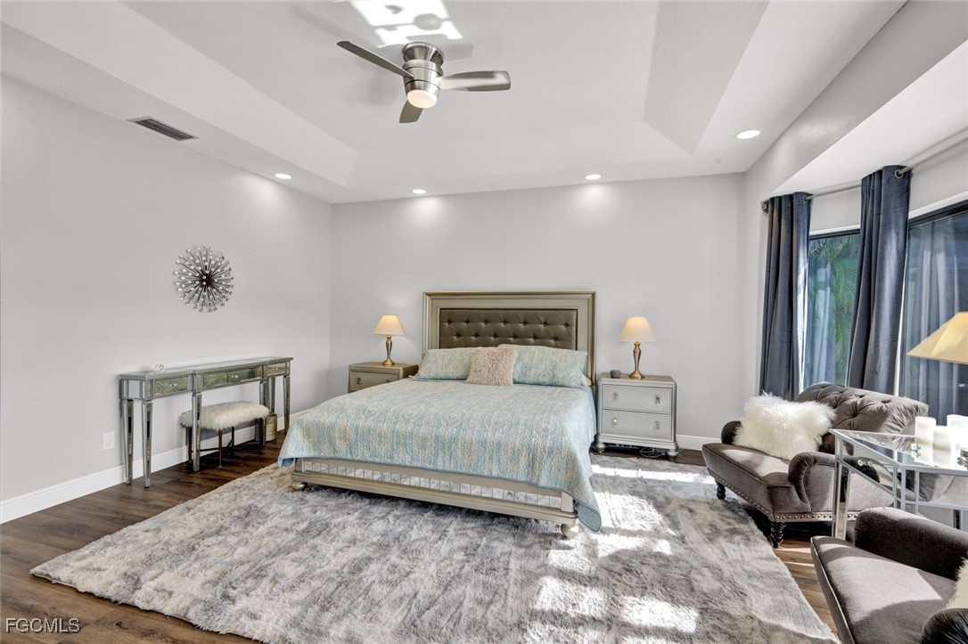 5346 Southwest 10th Avenue Cape Coral, FL 33914 - Photo 15 of 50 a bedroom with a bed a couches and wooden floor