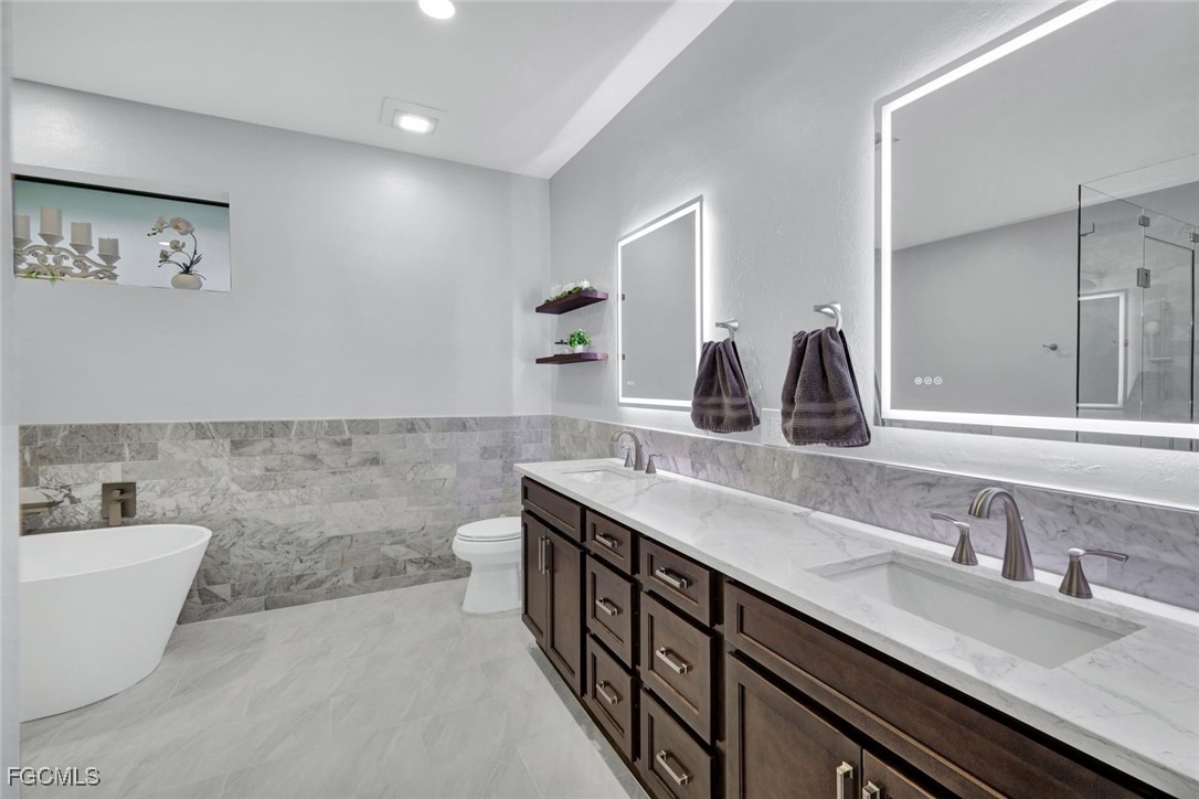 5346 Southwest 10th Avenue Cape Coral, FL 33914 - Photo 18 of 50 a bathroom with a double vanity sink and a bathtub