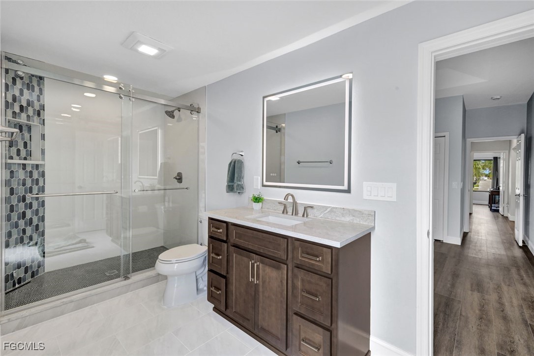 5346 Southwest 10th Avenue Cape Coral, FL 33914 - Photo 22 of 50 a bathroom with a double vanity sink toilet mirror and shower