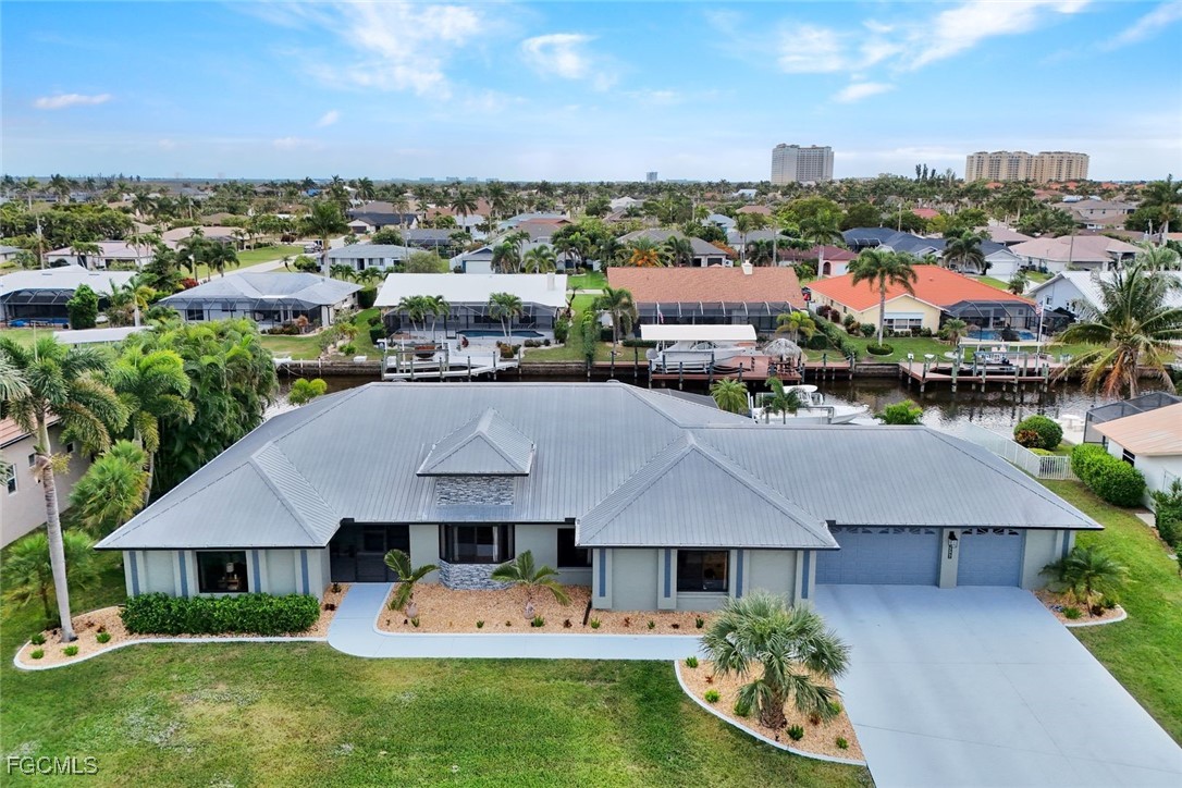 5346 Southwest 10th Avenue Cape Coral, FL 33914 - Photo 3 of 50 a aerial view of a house with garden space and a car park