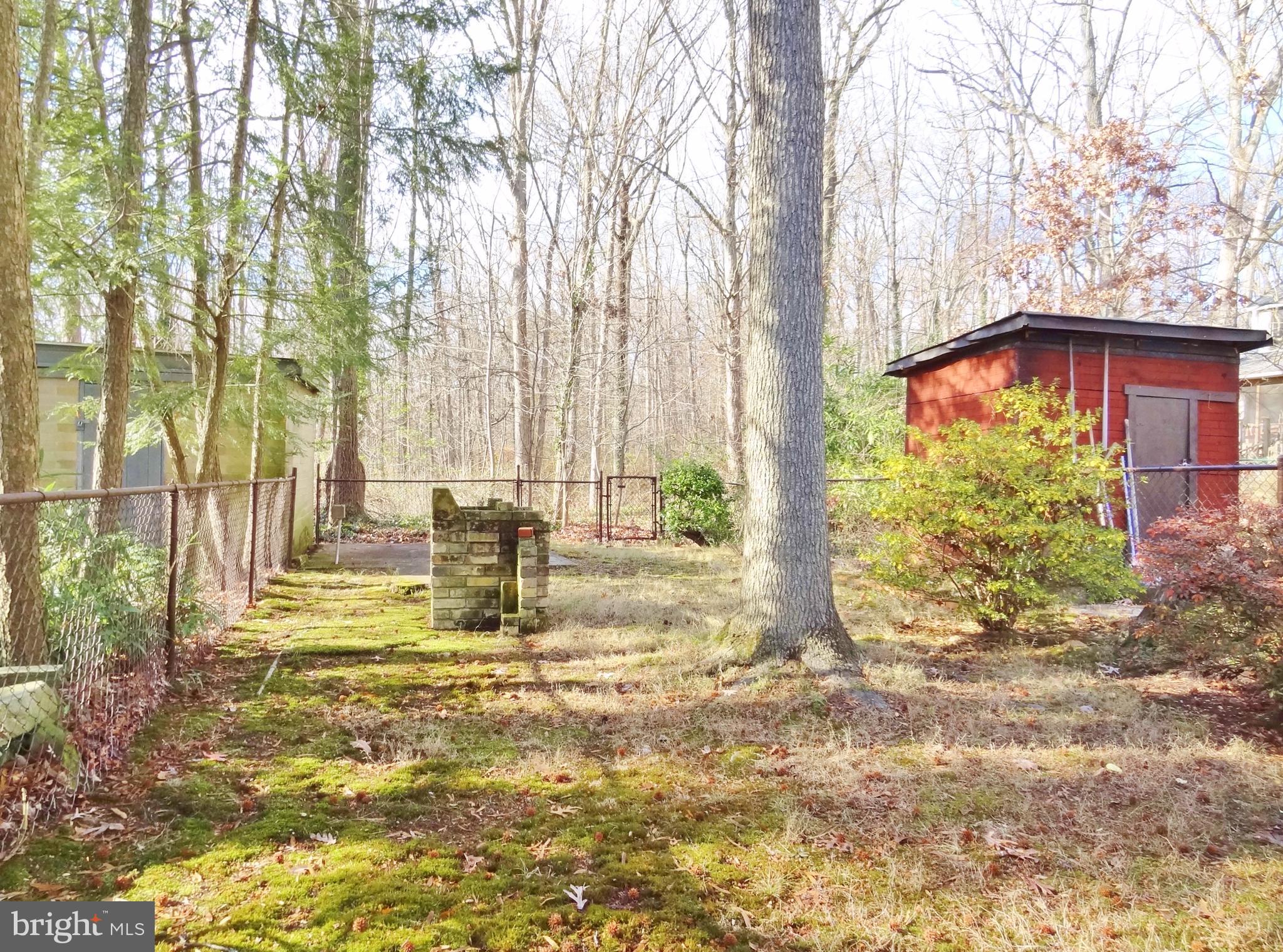 1 Research Road, Unit C Greenbelt, MD 20770 - Photo 5 of 9 Fenced backyard with stone BBQ pit
