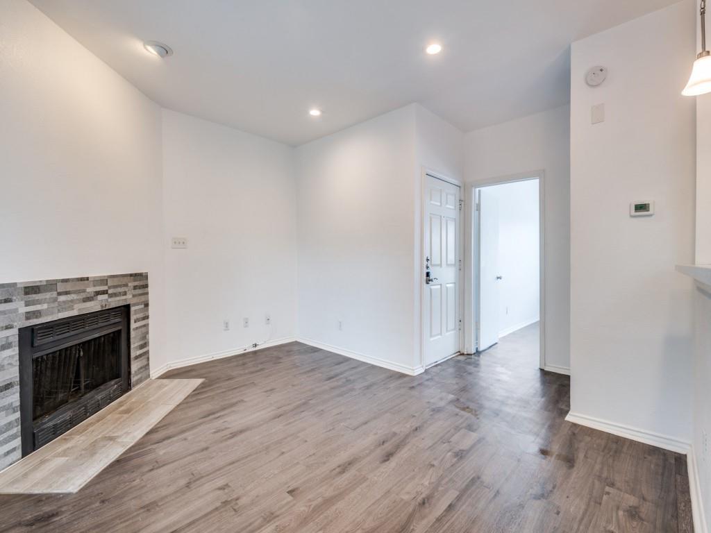 4113 Esters Road, Unit 605 Irving, TX 75038 - Photo 4 of 8 an empty room with wooden floor and fireplace