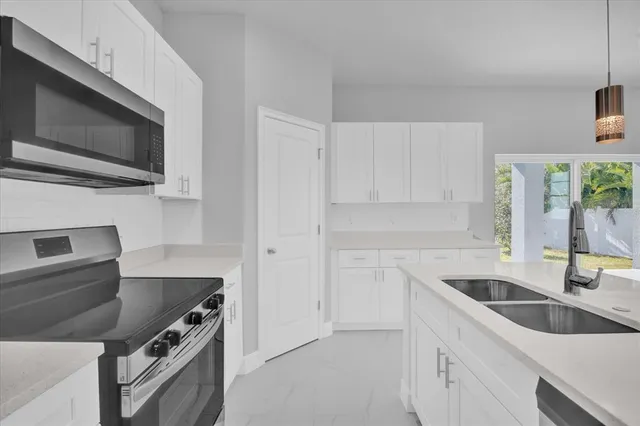 a kitchen with a sink and steel appliances