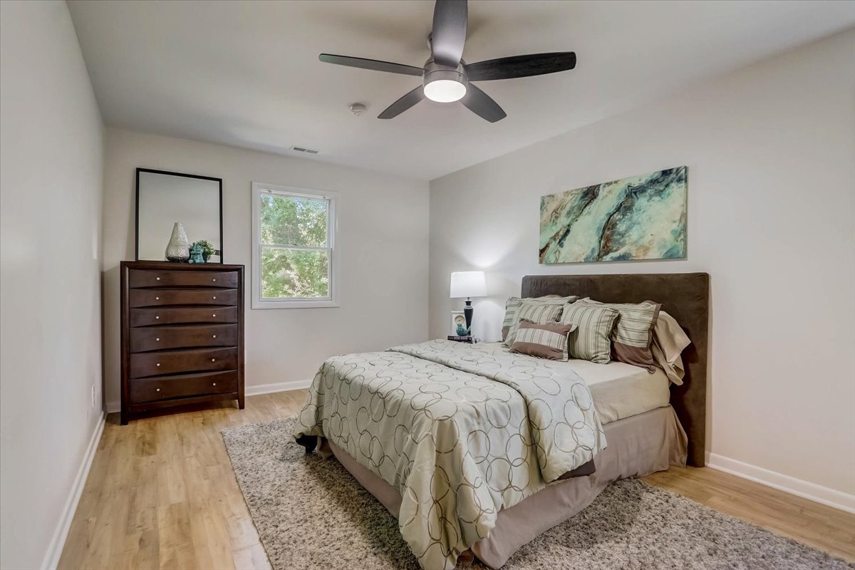 124 Hickory Road Lake In The Hills, IL 60156 - Photo 18 of 49 a bedroom with a bed and a chandelier