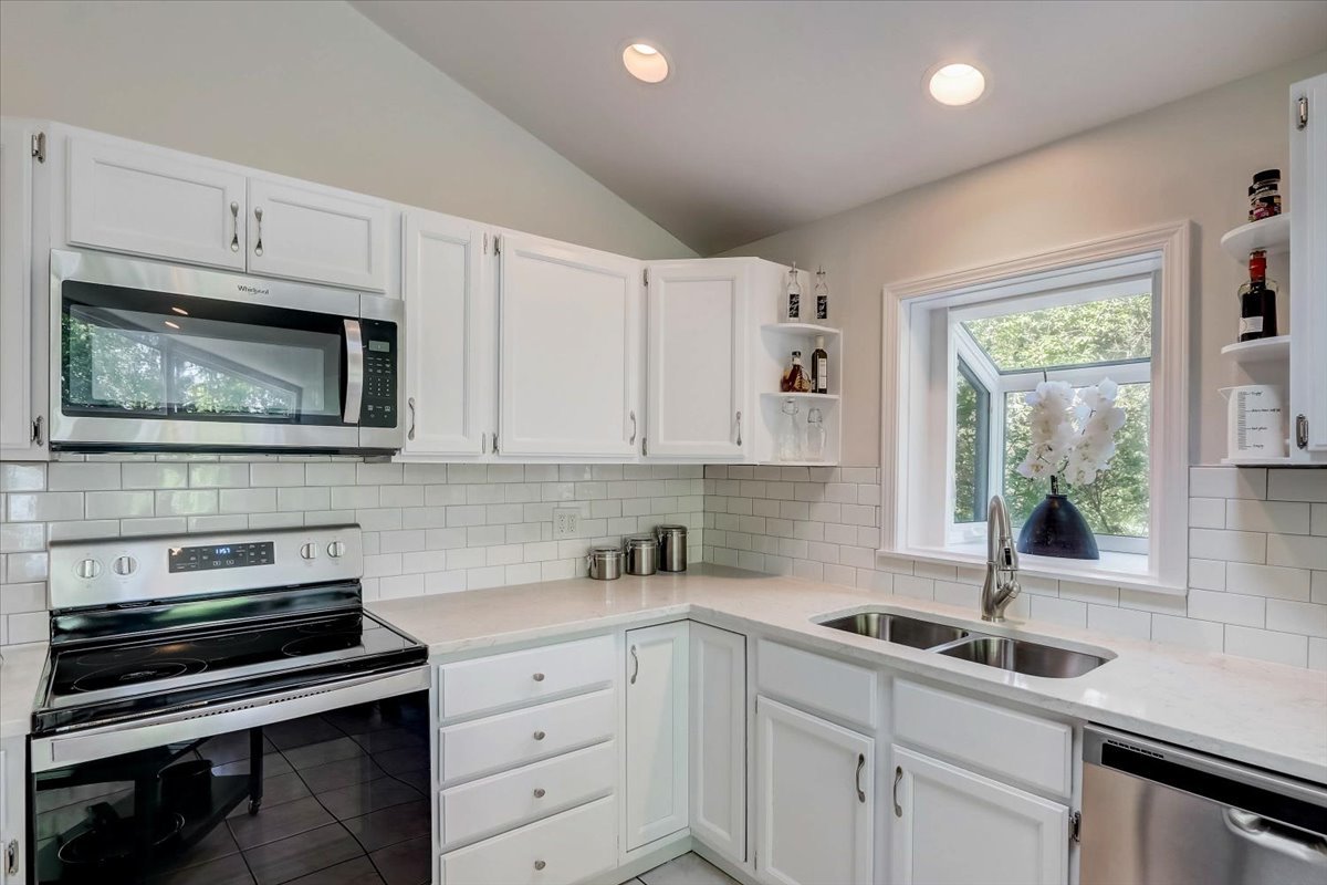 124 Hickory Road Lake In The Hills, IL 60156 - Photo 6 of 49 a kitchen with granite countertop a sink a stove and cabinets