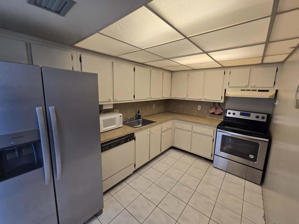 6195 Rock Island Road, Unit 209 Tamarac, FL 33319 - Photo 11 of 40 a kitchen with a refrigerator sink and cabinets