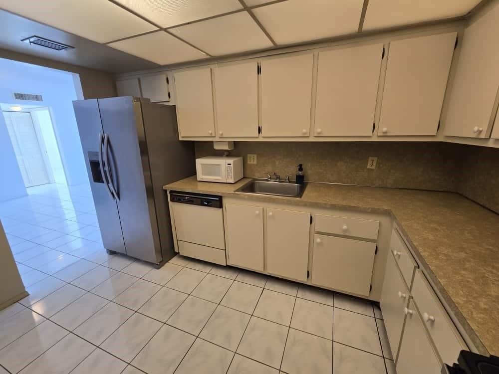 6195 Rock Island Road, Unit 209 Tamarac, FL 33319 - Photo 12 of 40 a kitchen with cabinets and a refrigerator