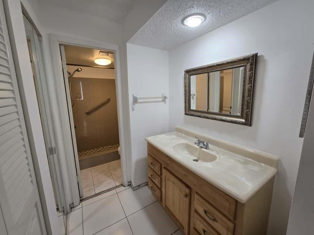 6195 Rock Island Road, Unit 209 Tamarac, FL 33319 - Photo 23 of 40 a bathroom with a sink a mirror and a shower