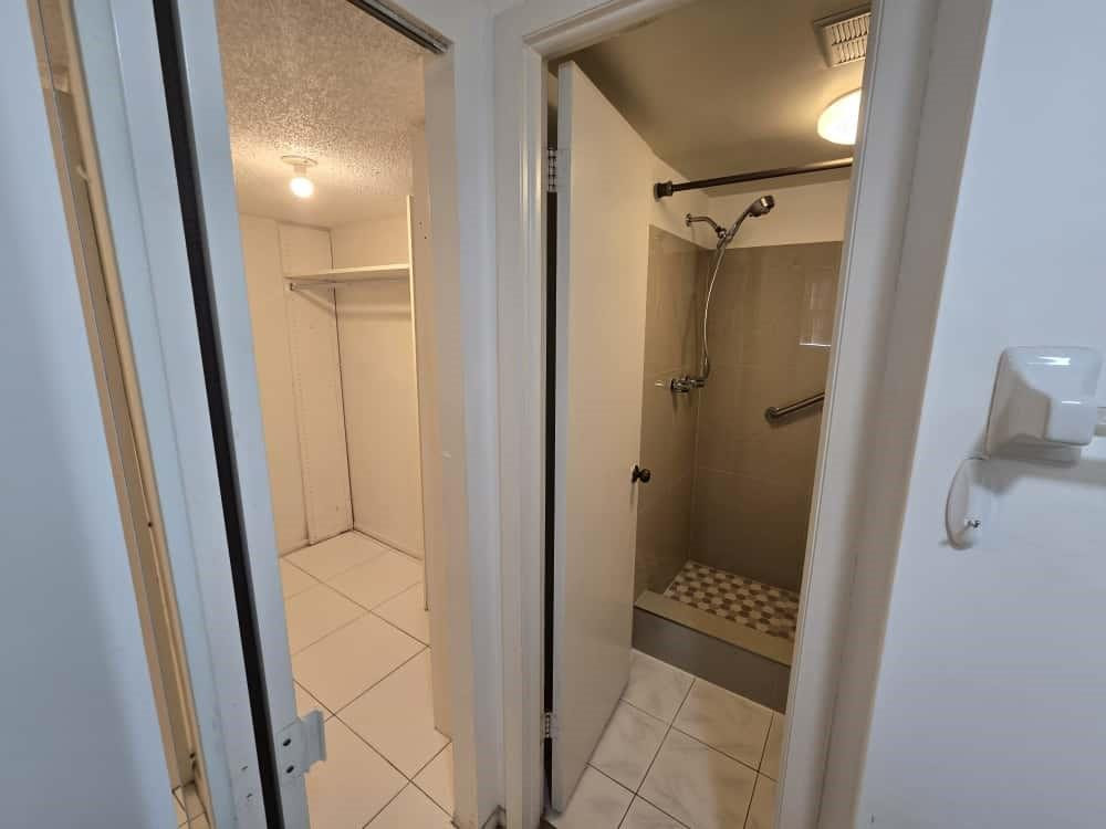 6195 Rock Island Road, Unit 209 Tamarac, FL 33319 - Photo 26 of 40 a bathroom with a glass door shower and a mirror