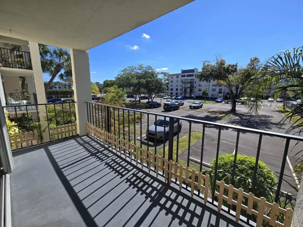 6195 Rock Island Road, Unit 209 Tamarac, FL 33319 - Photo 36 of 40 a view of a balcony with wooden floor and outdoor seating