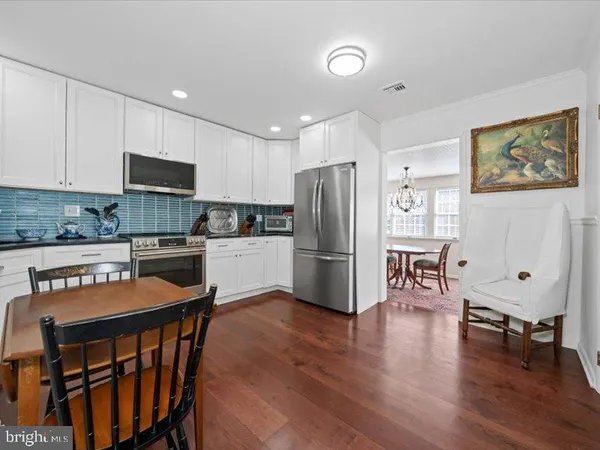a kitchen with stainless steel appliances a sink a stove a table and chairs