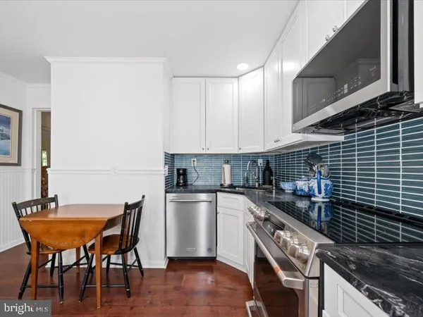 a kitchen with stainless steel appliances granite countertop a refrigerator a stove and a refrigerator