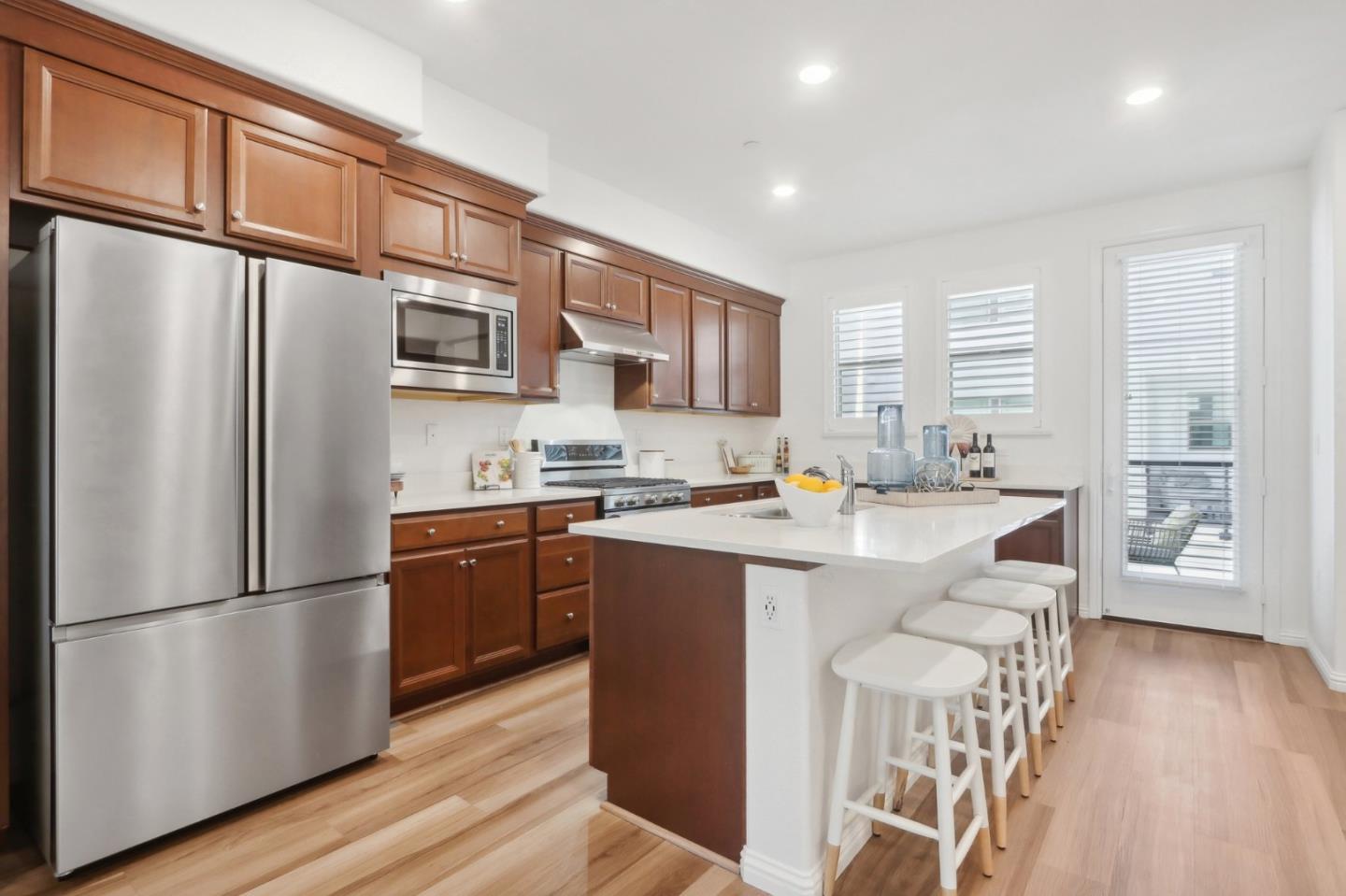 5766 Stealth Loop San Jose, CA 95119 - Photo 15 of 48 a kitchen with stainless steel appliances granite countertop a refrigerator a stove a sink dishwasher and a refrigerator with wooden floor