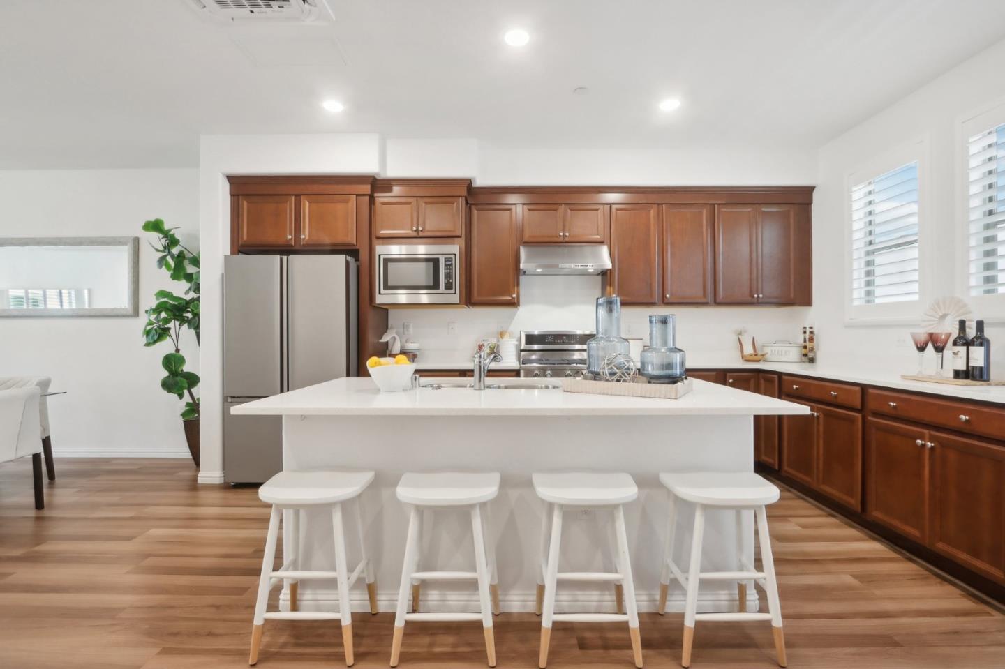 5766 Stealth Loop San Jose, CA 95119 - Photo 16 of 48 a kitchen with a dining table chairs refrigerator and cabinets
