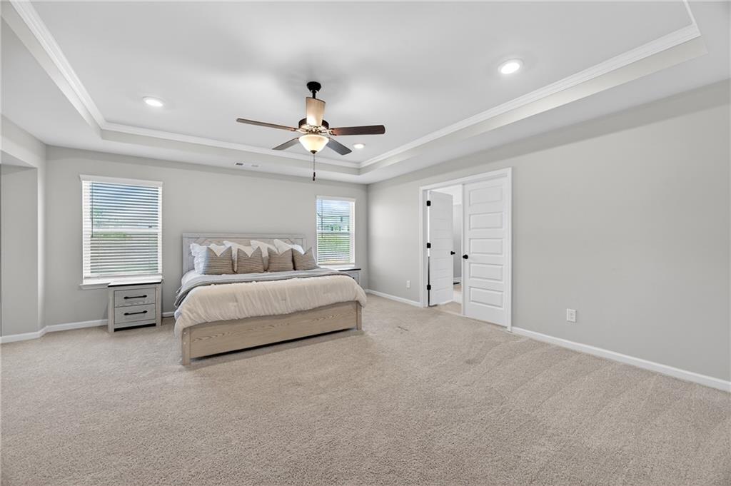 150 Buffalo Trace Stockbridge, GA 30281 - Photo 22 of 35 a spacious bedroom with a bed and a chandelier