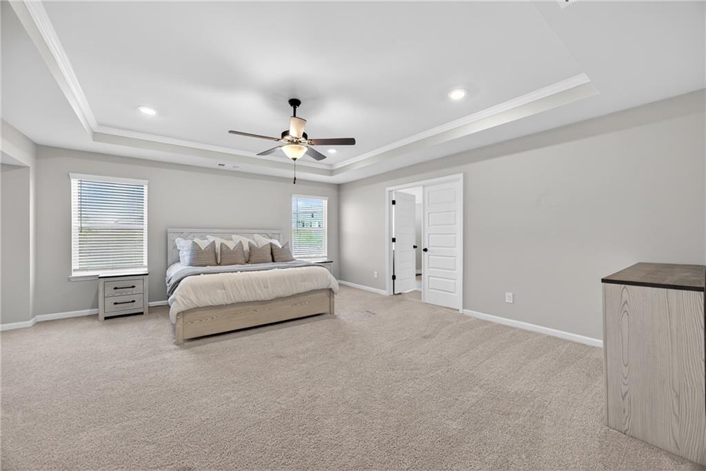 150 Buffalo Trace Stockbridge, GA 30281 - Photo 23 of 35 a spacious bedroom with a bed and a chandelier