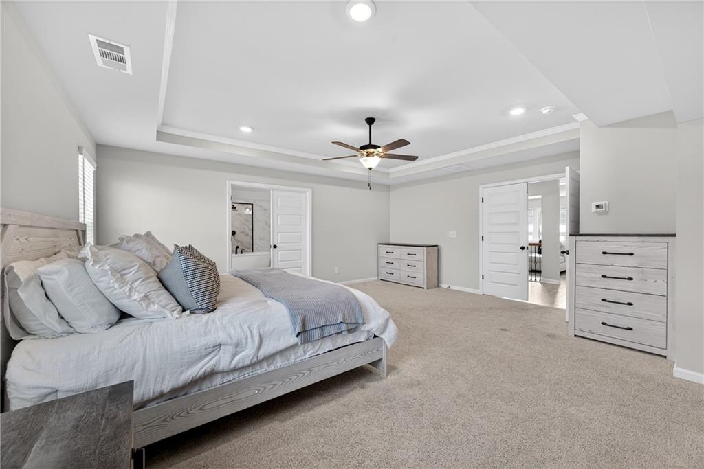 150 Buffalo Trace Stockbridge, GA 30281 - Photo 26 of 35 a bedroom with a bed and a chandelier