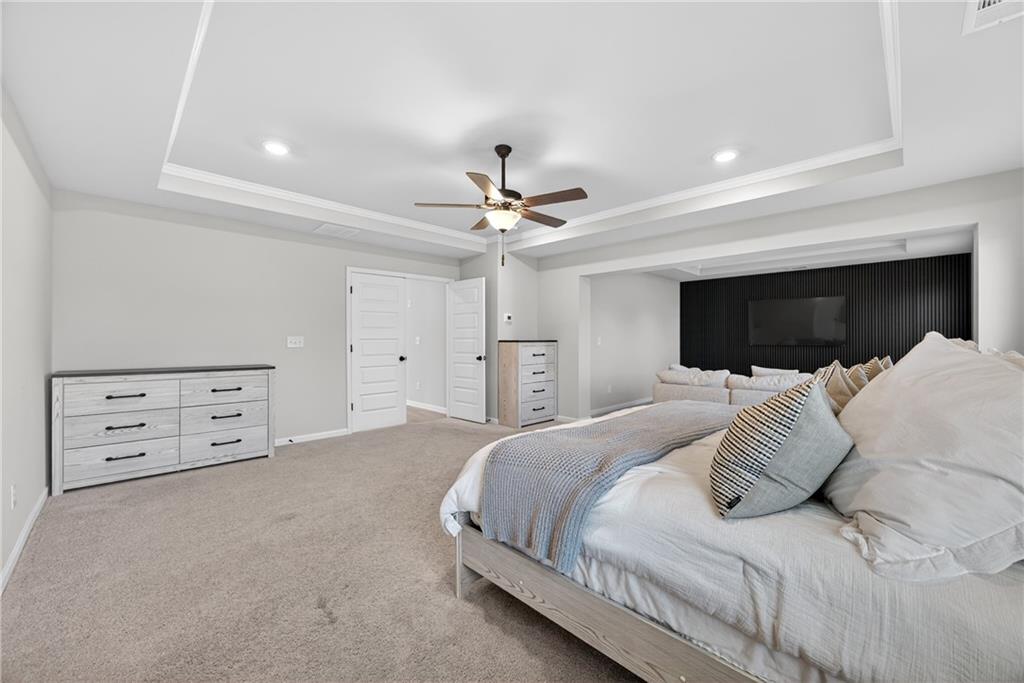 150 Buffalo Trace Stockbridge, GA 30281 - Photo 27 of 35 a bedroom with a large bed and a ceiling fan